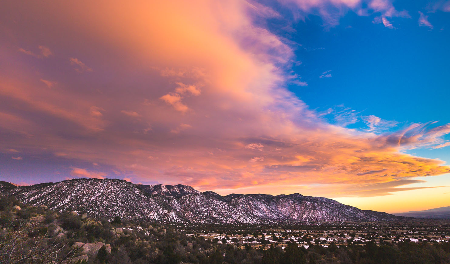 Image of a pink and orange sunset over the Albuquerque and the Sandia mountains